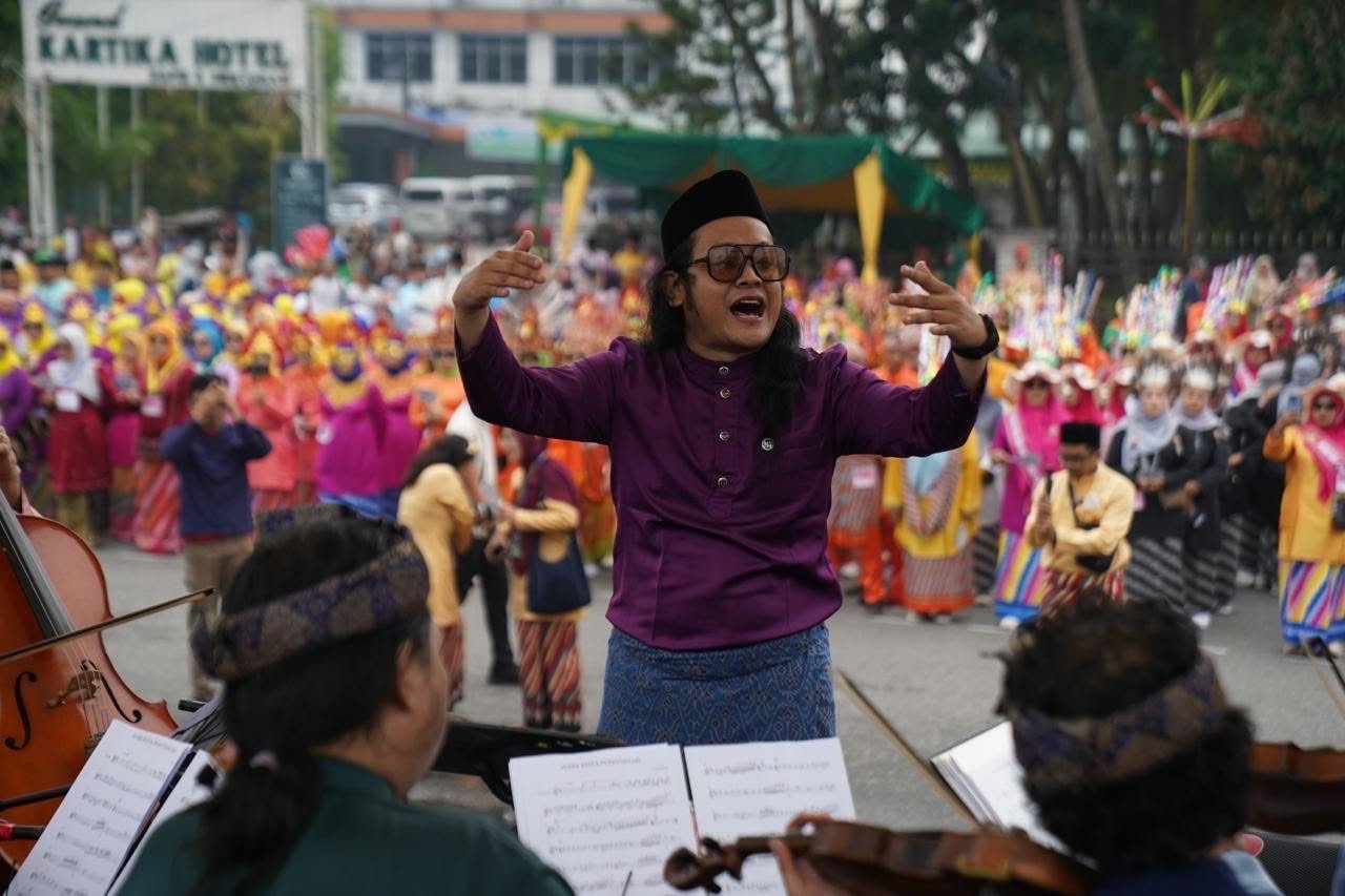 Daun Selasih Orchestra dengan conductor Peri Rakhmadi saat membawakan Mars Kota Pontianak dalam peringatan Hari Jadi ke 255 Pontianak di depan Kantor Wali Kota Pontianak, Jumat (23/10/2026). HALKALBAR.ID/Istimewa.